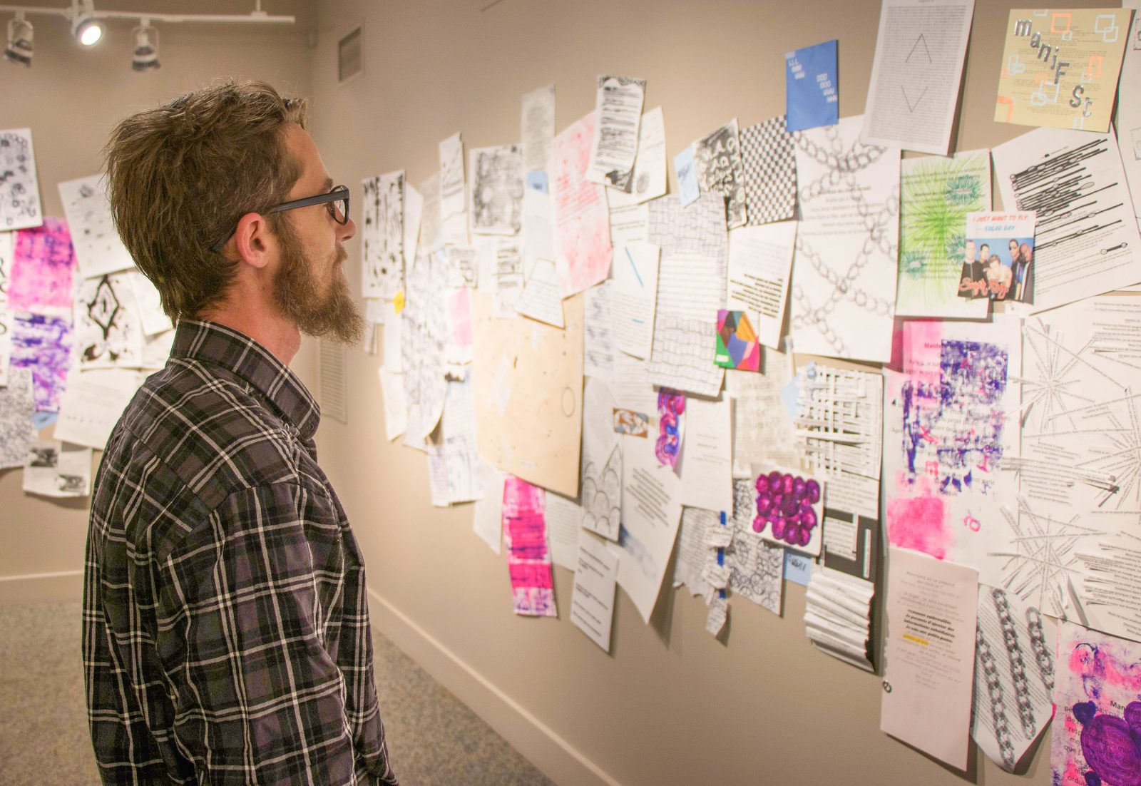 Curt Richard, a student in VISA 3M90, surveys the exhibition that he and 52 other students have completed over the course of the semester.