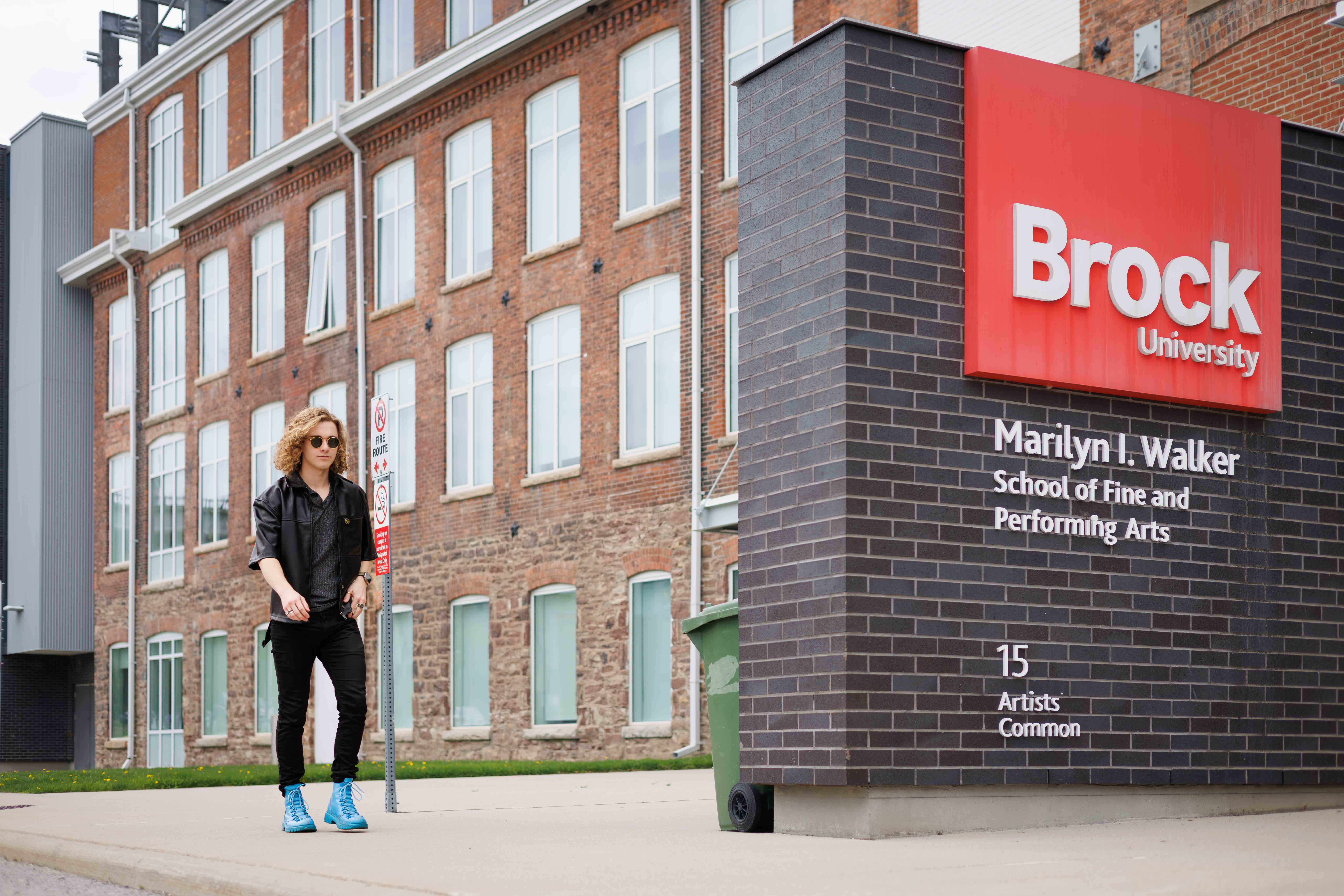Photo of student wearing blue boots walking into Marilyn I. Walker School of Fine and Performing Arts.