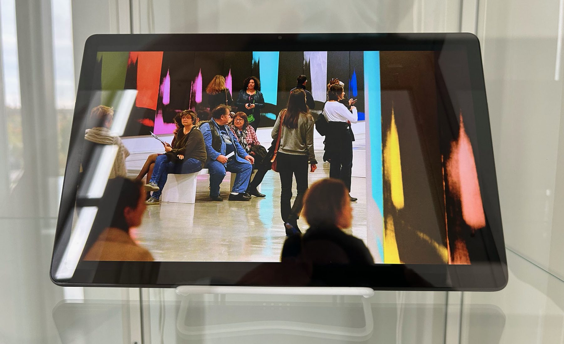 Ipad with an image of people in an artgallery lobby 