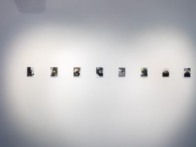 8 black and white photos hanging on a white gallery wall