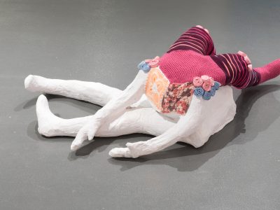 abstract sculpture of a colourful figure on a grey floor