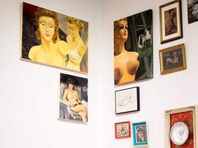 group of female painted portraits hung in the corner of an art exhibit