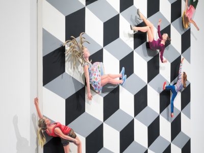 closeup of a geometric pattern with dolls glued on