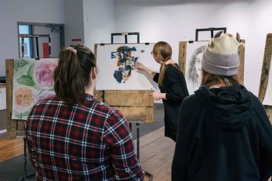 Students discuss a painting in their Studio class