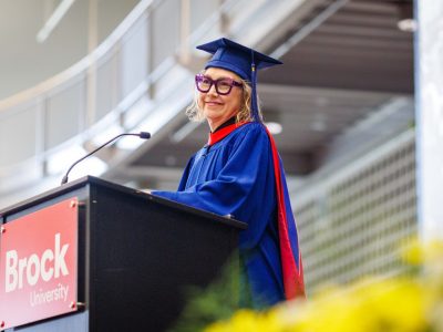 Photo of Donna Szoke in cap and gown giving convocation speech.