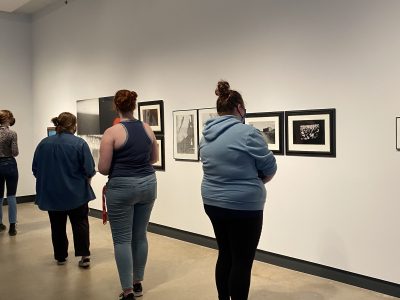people in a gallery looking at various artwork hanging on wall