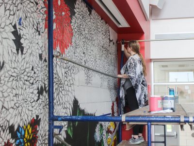 Fourth-year Visual Arts student Chardon Trimble-Kirk beginning of painted mural