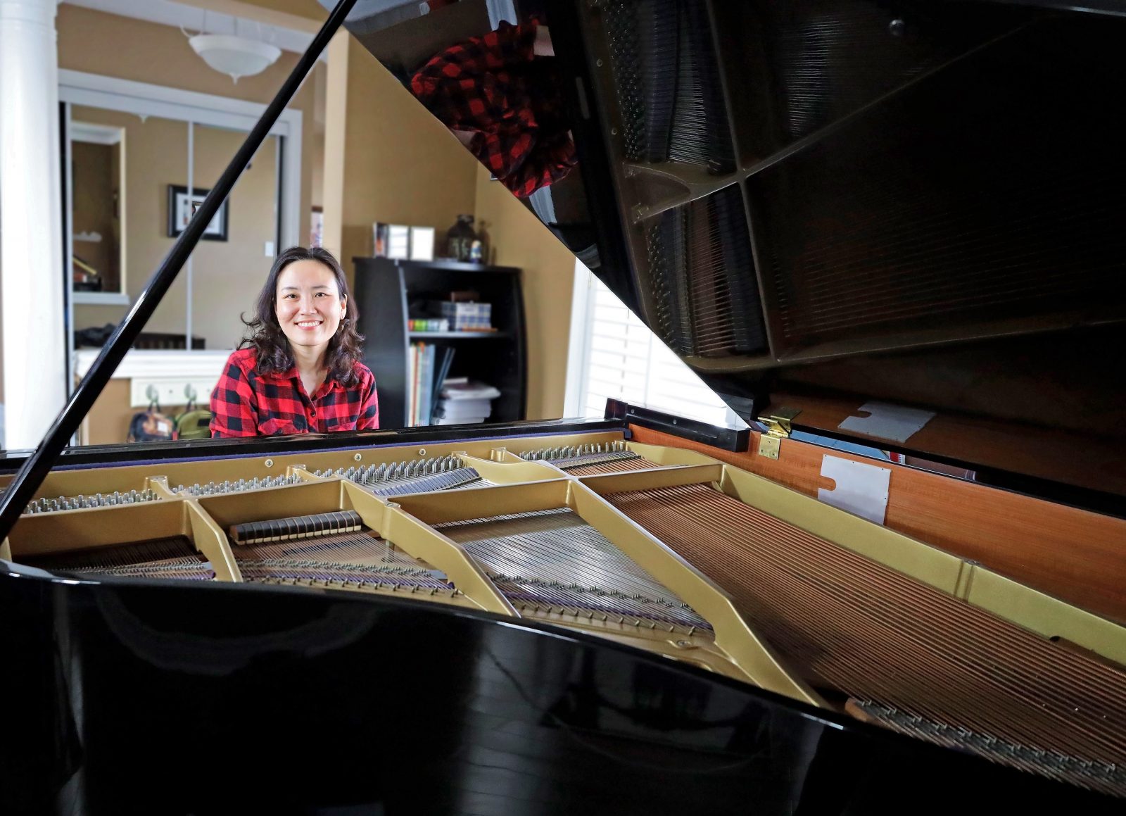 female student behind a piano at the keys