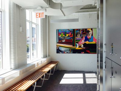 artwork display in a hallway with benches and windows