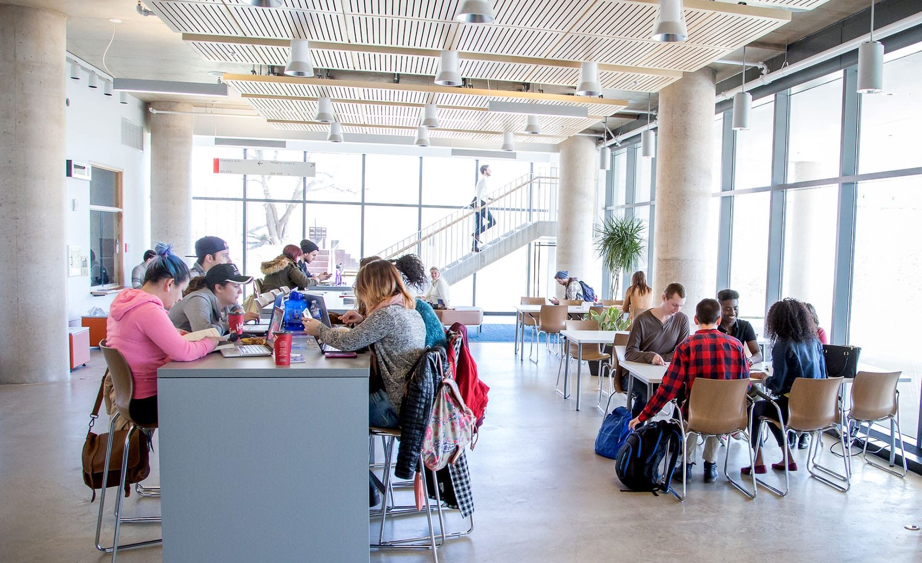 lobby filled with students sitting at desk and benches