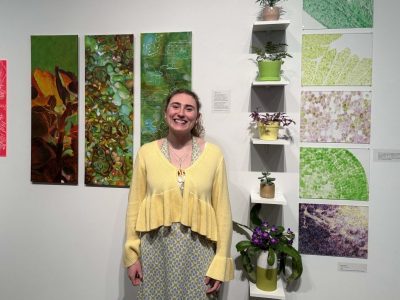 Photo of student standing in front of plant-inspired artwork.