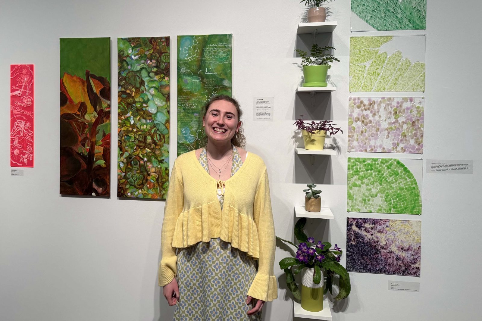 Photo of student standing in front of plant-inspired artwork.