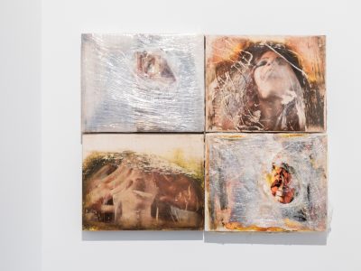 goup of 4 portrait artworks hanging on gallery wall