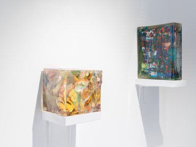 2 colourful cube sculputers on a shelf hanging on gallery wall