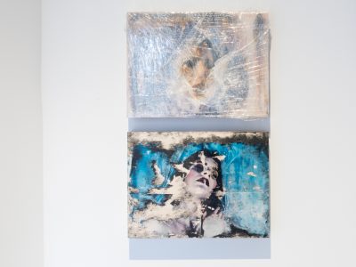 2 abstract portraits hanging on gallery wall