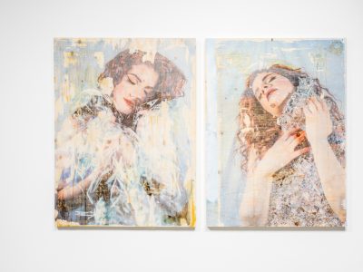 2 abstract female portraits hanging on gallery wall