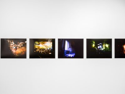 various photographic artwork hanging on gallery wall