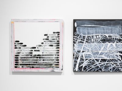 2 abstract artworks hanging on a gallery wall