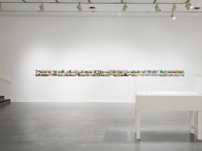 colourful long thin artwork on gallery wall with bench