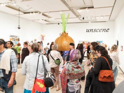 Crowd of attendees view an exhibition in the VISA gallery.