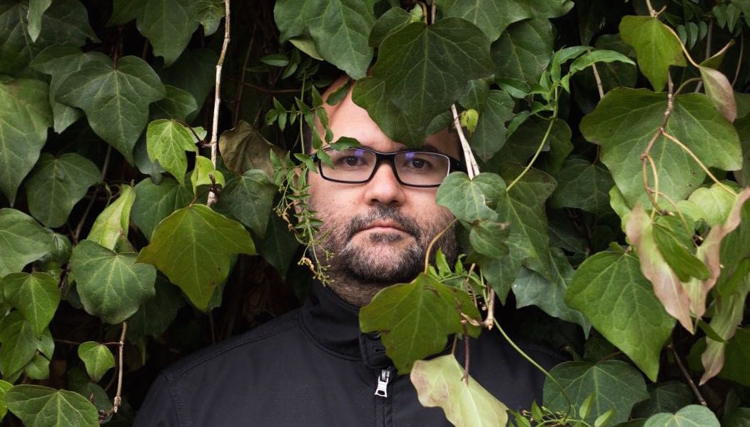 Alejandro Cartagena portrait within green leaves