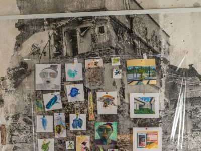 artwork display of various prints in front of a building on rocks