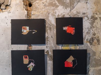 4 art prints in front of decaying cement wall