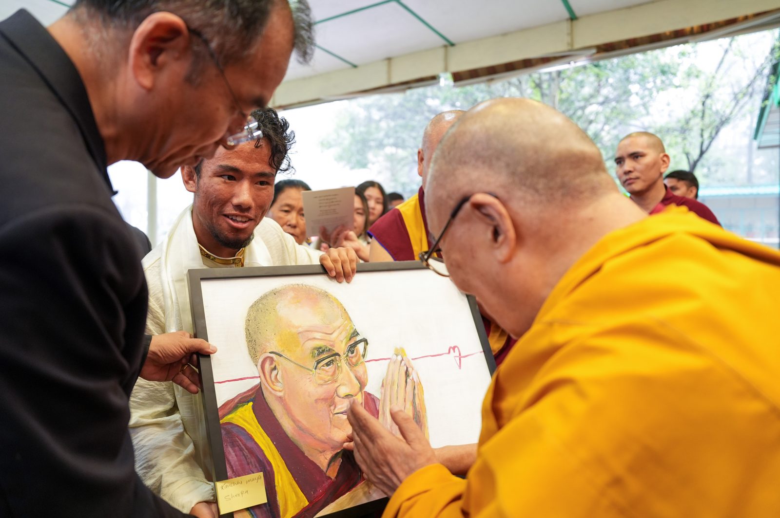 Student presenting the Dalai Lama with a portrait.
