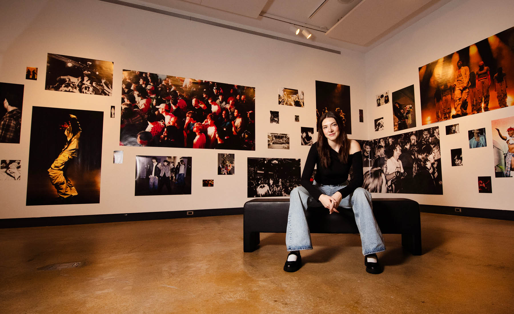 Photo of VISA student in VISA gallery displaying her work 