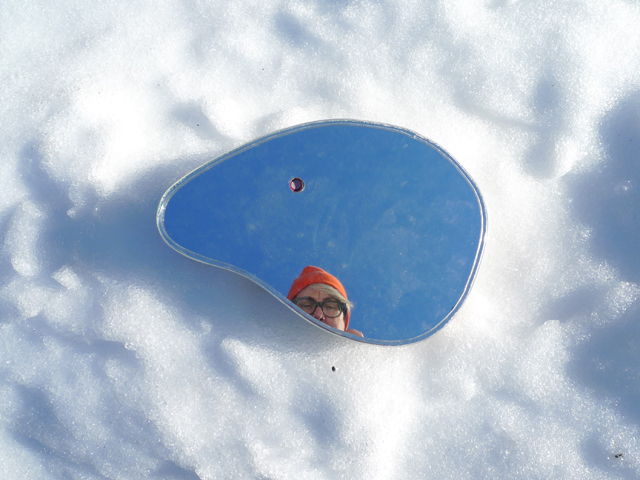 Donna Akrey partial face viewed from shiny metal in snow