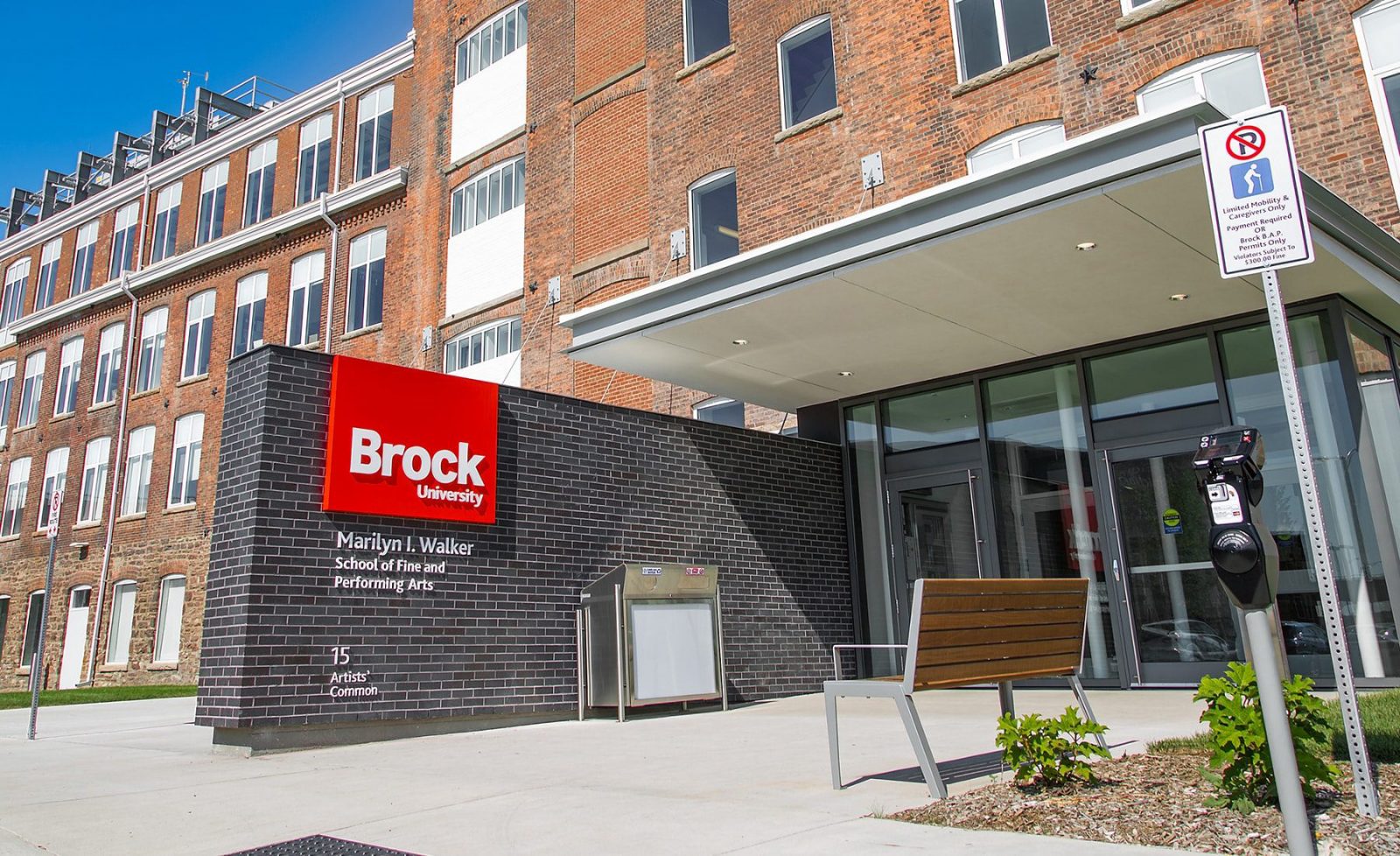 The brown brick exterior and glass entrance to the Marilyn I. Walker School of Fine and Performing Arts, with clear blue skies in the background.