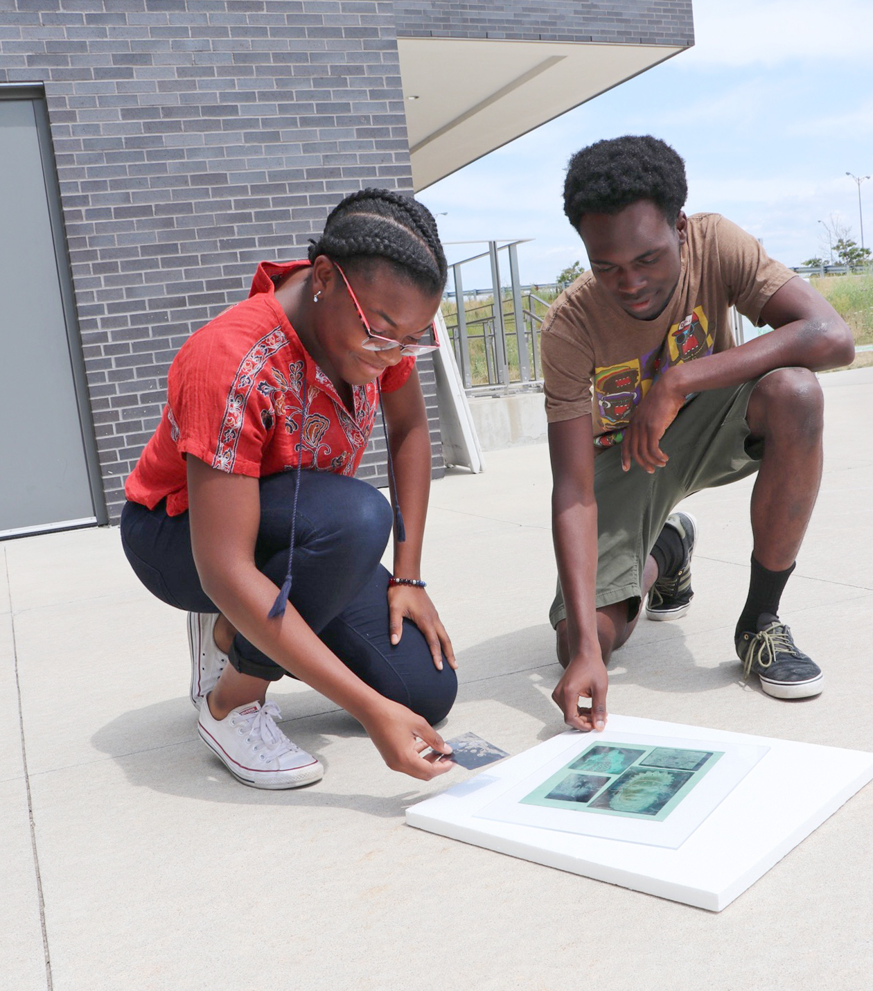 Chidera Onyegbule and Osaze Usuanlele make cyanotypes outside building