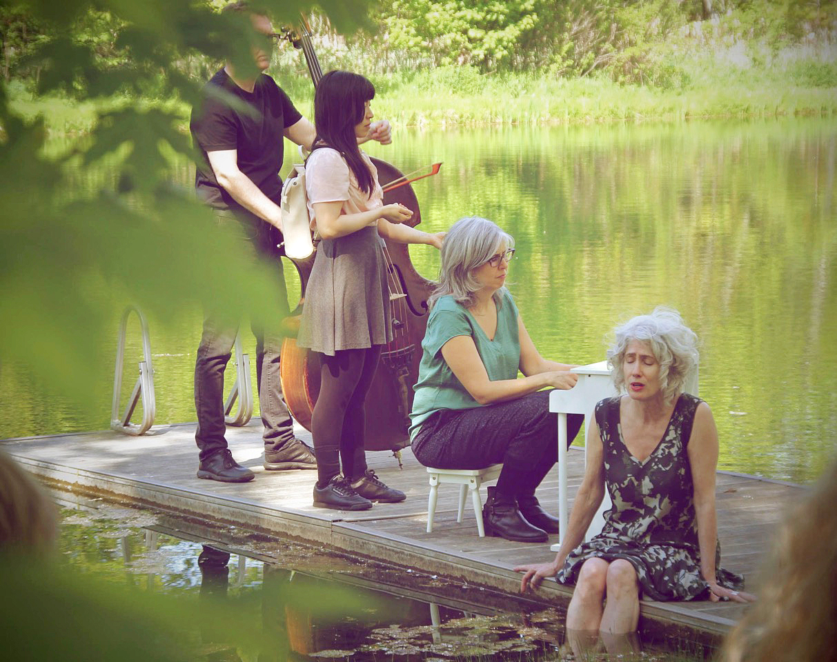 Fides Krucker sits on a dock with her colleagues, while singing. Krucker is the first speaker in the walker cultural leader series.