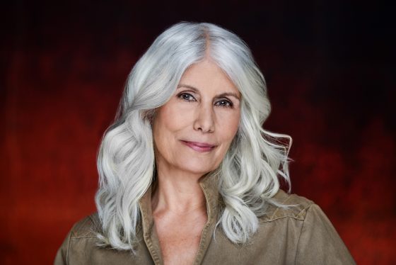 Headshot of Jani Lauzon against maroon background.
