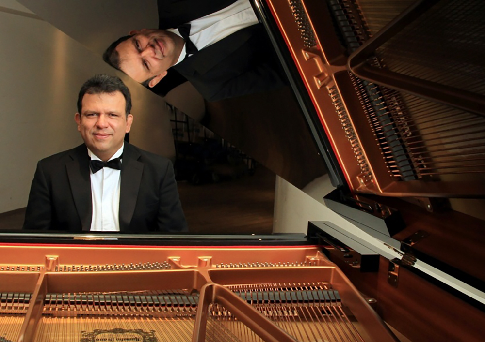 Luis Gerardo Molina sitting at a piano