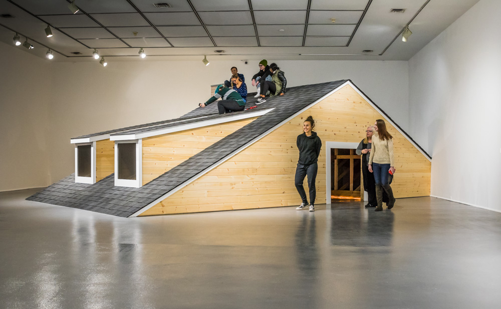 People are sitting on a roof that is built inside of Rodman Hall