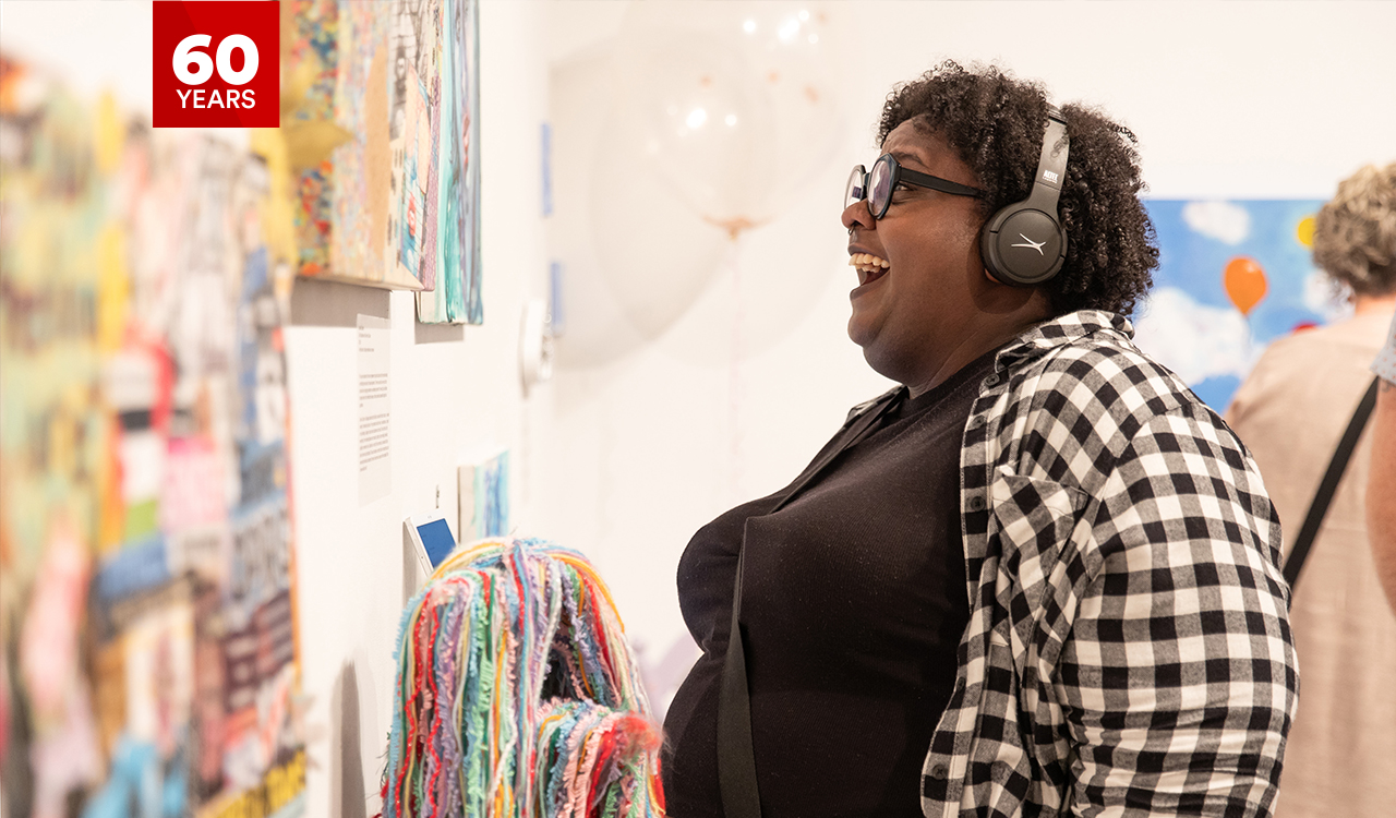 Photo of delighted attendee viewing art in the VISA gallery.