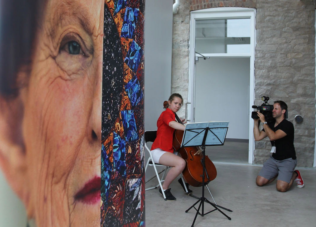 Marilyn I Walker portrait in view of a female cellist plying in front of a camera man