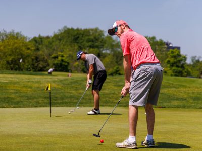 Golfers practice putting