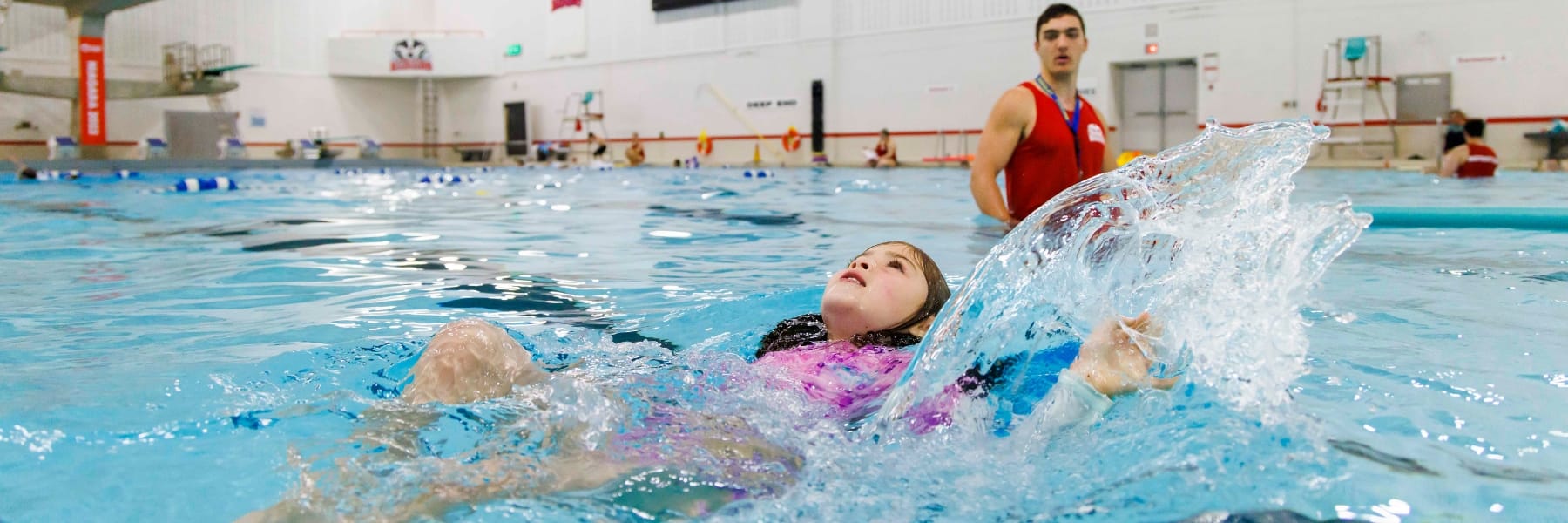 child and swim instructor in pool