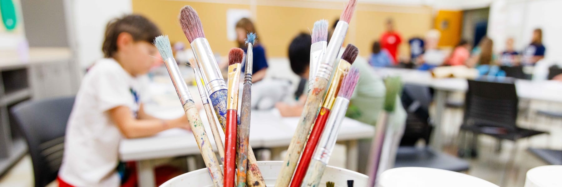 Cart supplies with children making art in background