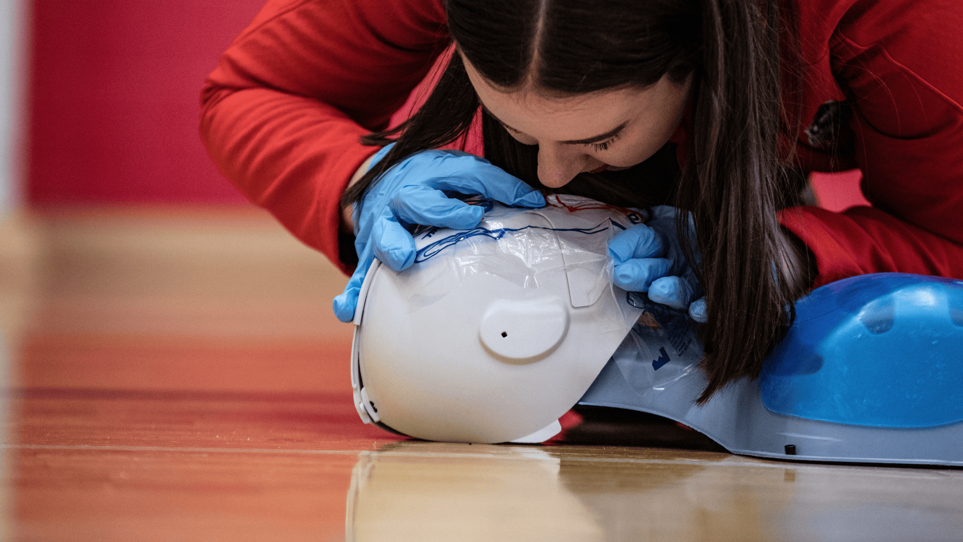 Student performing CPR on a first aid mannequin 