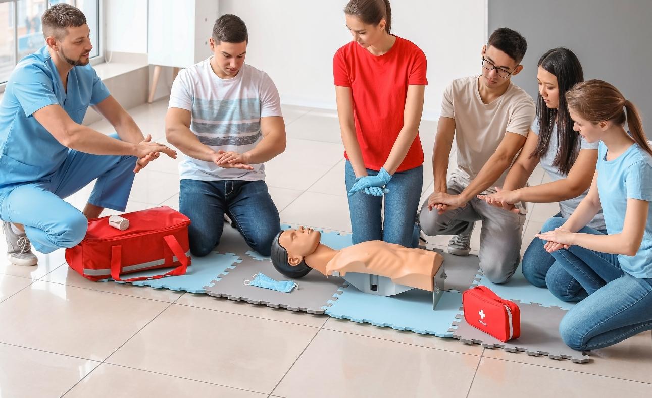 students learning first aid and cpr on mannequin 