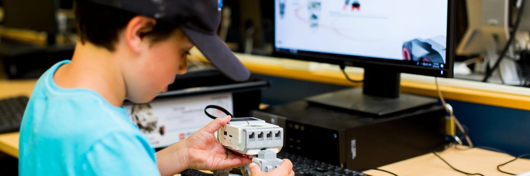 Child working with a computer and a robotics project