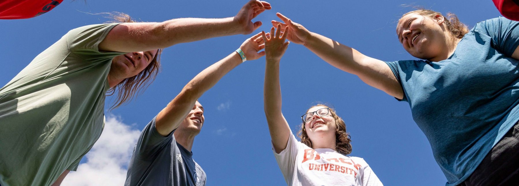 Brock students with hands in circle