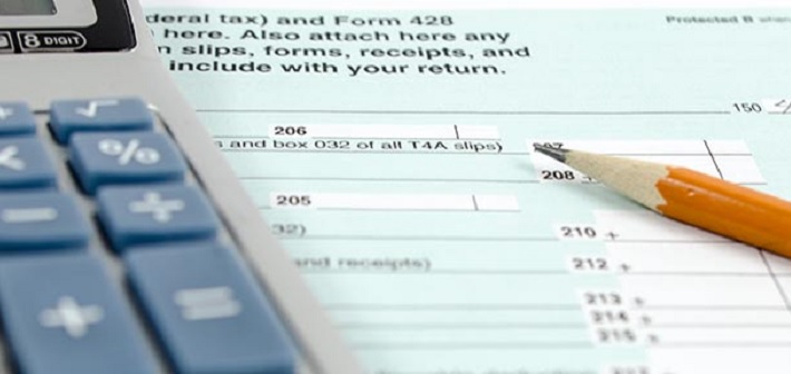 An image of a pencil and calculator resting on top of a tax form 