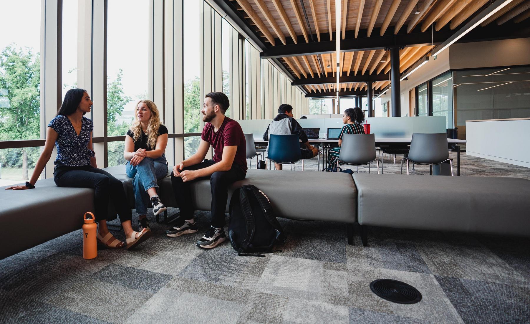 A group of students sitting in a brightly lit study lounge. 