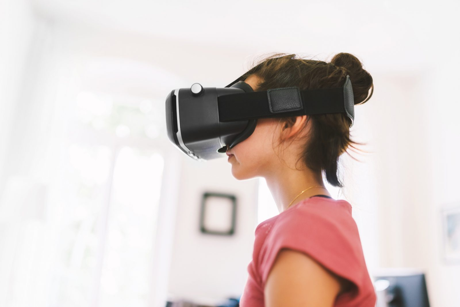 A young girl wears a virtual reality headset.