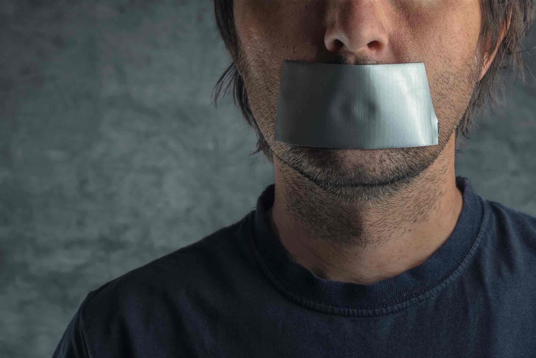 man with stubble and duct tape over mouth