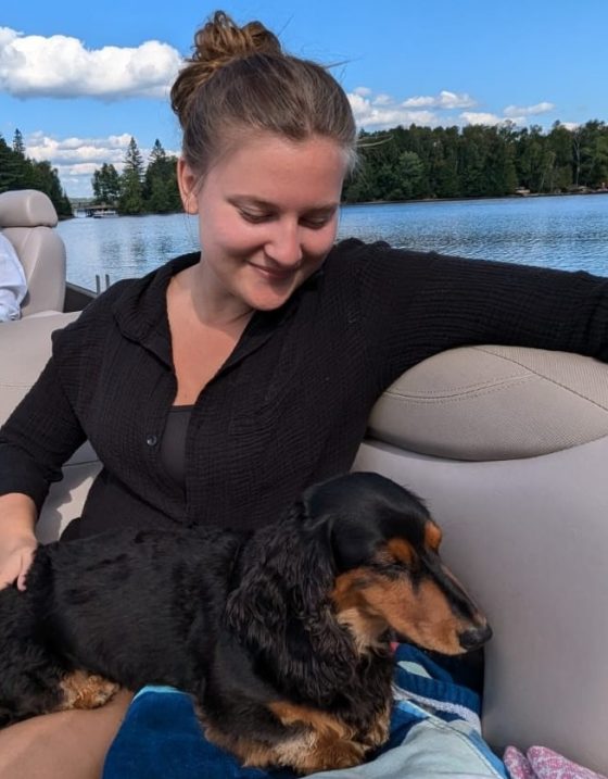Jill Ludwig on a boat with a dog in her lap.